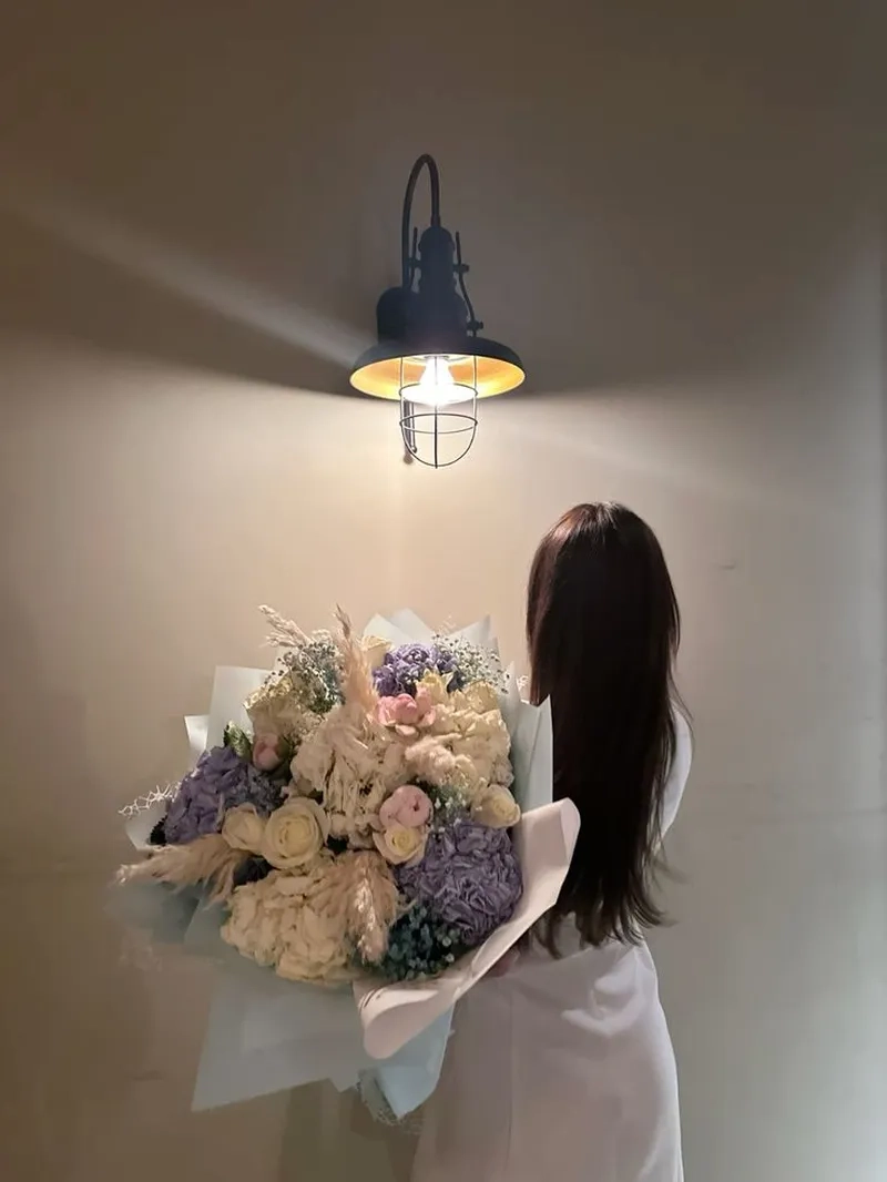 ảnh cô gái quay lưng cầm hoa trong nắng