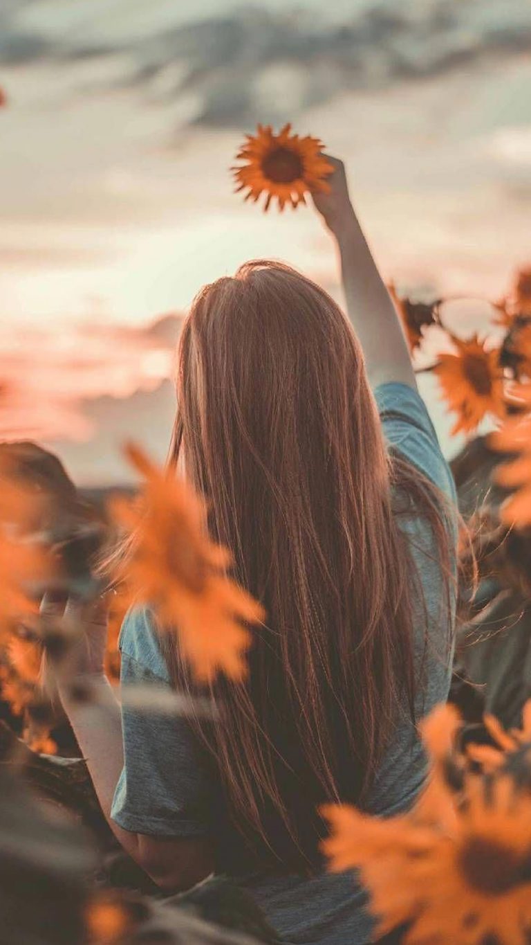 hình cô gái quay lưng cầm hoa trong nắng